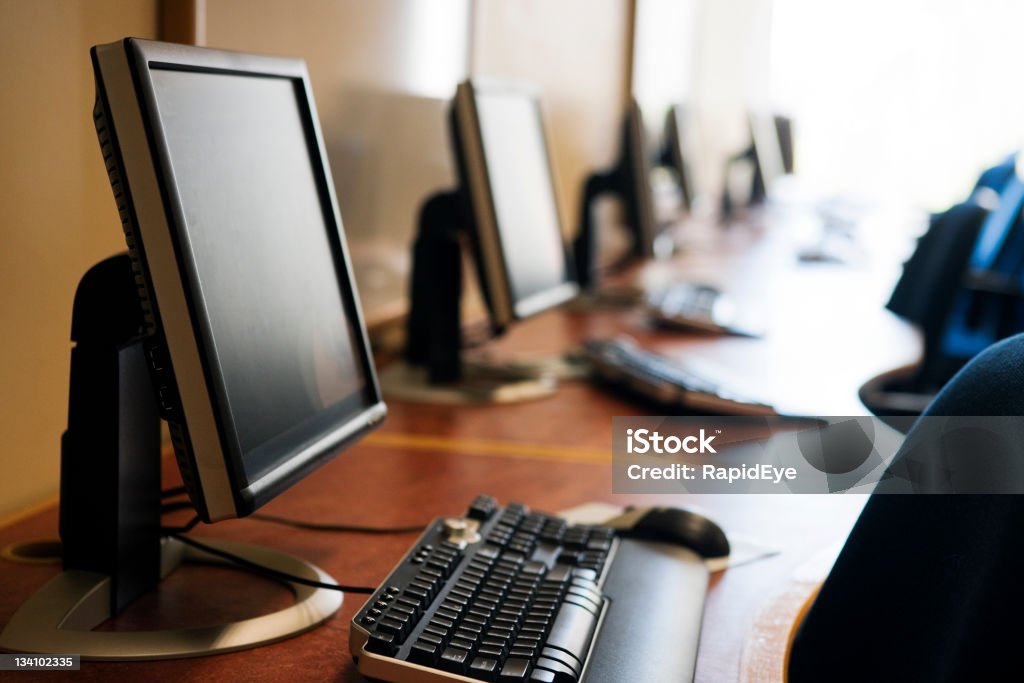 Computer room Row of modern screens and keyboards in a college computer lab. This image would work for an upmarket cybercafe too. Camera: Canon EOS 1Ds Mark III. Internet Cafe Stock Photo