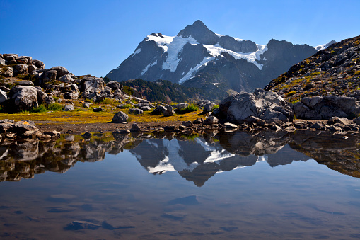 Stunning reflection of Mt. Shuksan in a tarn in autumn in Washington state