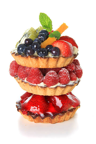 Different fruits tarts piled up on white background Fresh fruit pie tarts stacked on top of each other. mini kiwi stock pictures, royalty-free photos & images