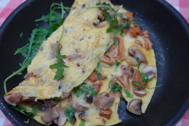 istock Omelette with Chanterelles and Paris mushrooms being cooked in a pan 1341032826