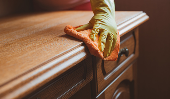 cleaning and maintenance of wooden furniture chair table with rag and cleaning agent.