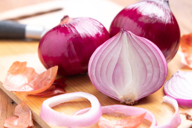 red onion and sliced onion on wooden cutting board. - spanish onion fotos imagens e fotografias de stock