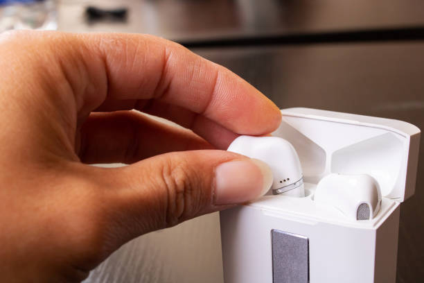 istock Hand takes out wireless earbuds close up 1341041293