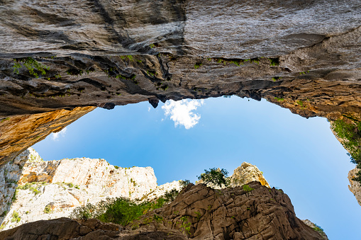 (Selective focus, focus) Stunning view from the bottom of the Gorropu gorge framing a blue sky. Gorropu is the deepest canyon in Europe located in the Supramonte area, Sardinia, Italy.