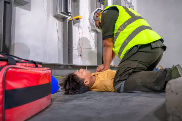 Photo of Electric worker suffered an electric shock accident unconscious. Safety team CPR for first aid Electric worker loses in electric shock accident at work on site. Accident in control room of factory.