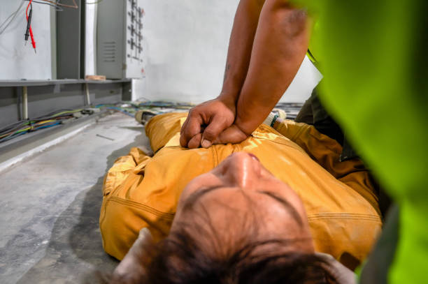 istock Electric worker suffered an electric shock accident unconscious. Safety team CPR for first aid Electric worker loses in electric shock accident at work on site. Accident in control room of factory. 1341045196