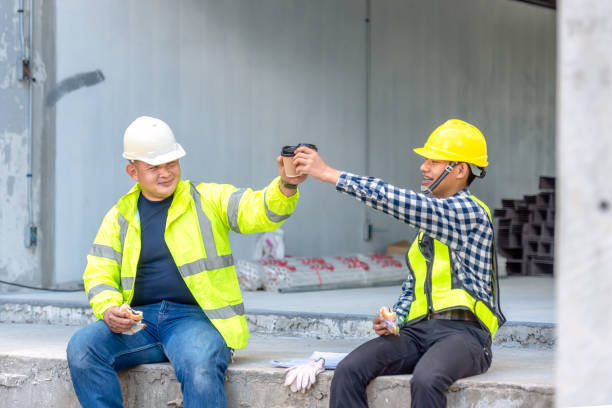 istock Construction worker, foreman sits and talks with the engineer who supervises the construction site. Construction Workers talking in coffee break in construction site. 1341045247