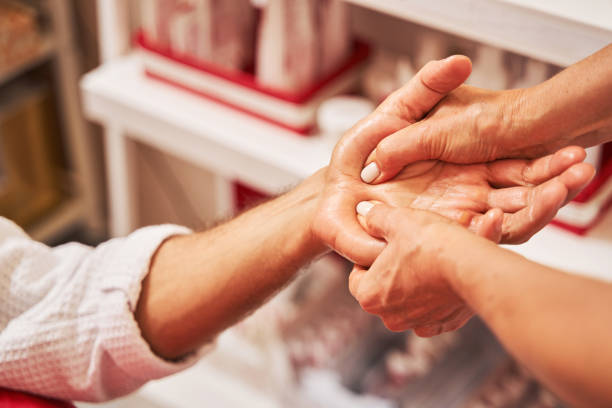 istock Massage therapist applying pressure on man palm with thumbs 1341045434