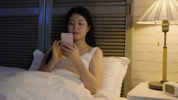 istock woman texting on smartphone in bed at home night 1341046987