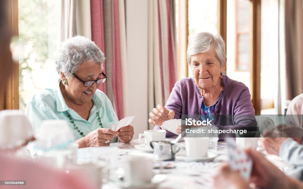 Shot of a group of senior women playing cards together at a retirement home Keeping their minds stimulated Senior Adult Stock Photo