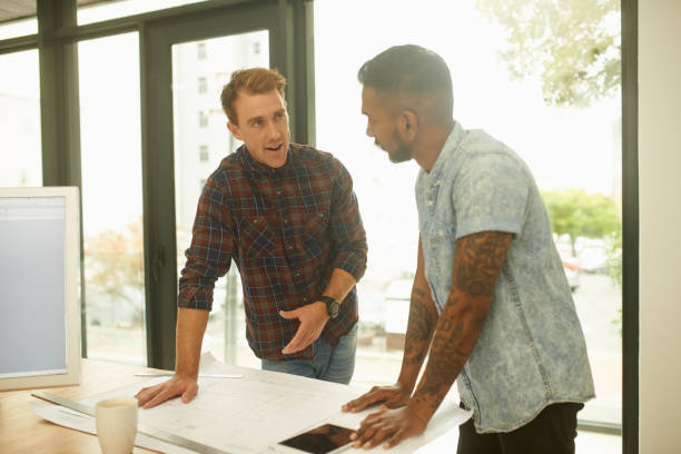 istock Shot of two young architects working on blueprints in an office 1341047724