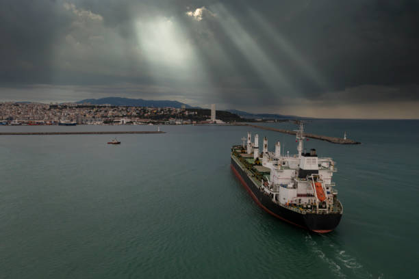 Loaded cargo  ship entering port after a rainy day.