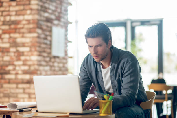 istock Man carefully looking into laptop screen 1341050878