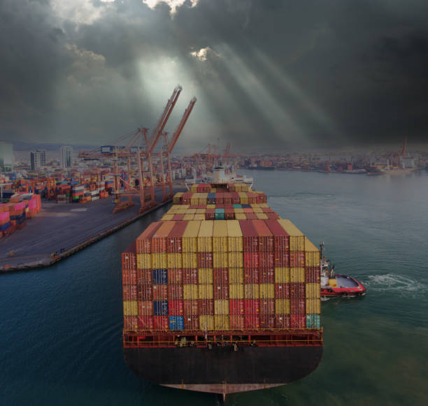 Loaded cargo container ship leaving port after a rainy day.