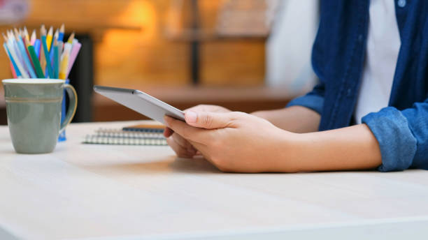 istock Close up of man hand using digital tablet for working at home, online study, telecommunication 1341053651