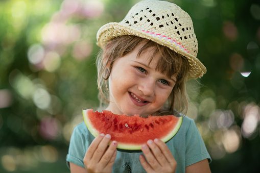 Girl eating slice of watermelon