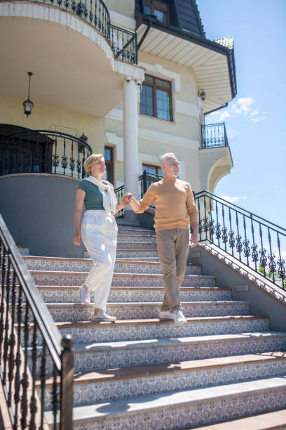 istock Two romantic middle-aged Caucasian spouses going downstairs 1341056028
