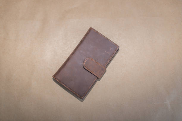 istock Man's brown leather wallet on beige background 1341058010