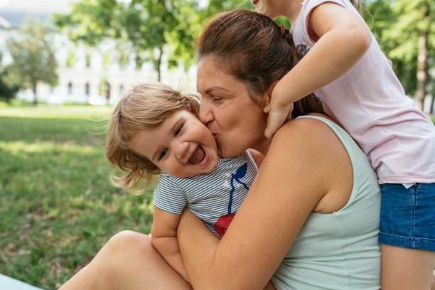 istock Pregnant mother with daughters in park 1341058700
