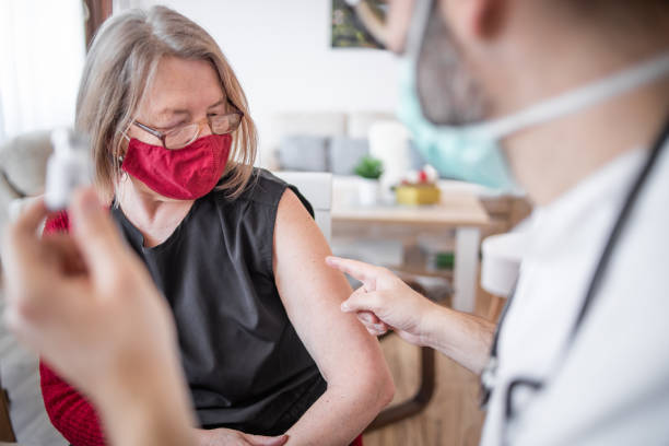 vacuna de refuerzo covid 19. el médico le da la vacuna a una mujer mayor. - rocket booster fotografías e imágenes de stock