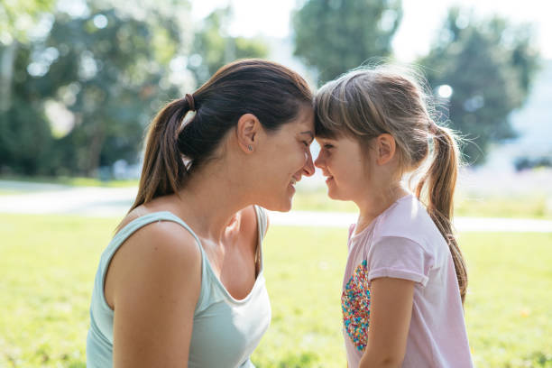 istock Pregnant mother with daughters in park 1341059400