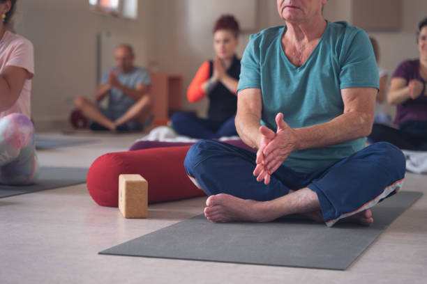 istock group, of different ages, in a yoga class, rubbing their hands together before beginning the practice of Yoga Mudra. 1341063550