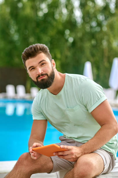 istock A bearded young man with a tablet in hands 1341063589