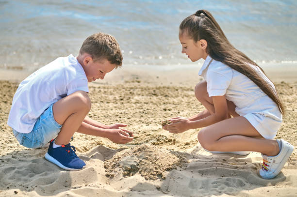 Sand castles. Two kids making sand castles and looking involved