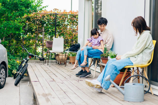 自宅の庭でリラックスしている女の子と彼女の家族 - 家族　旅行　日本 ストックフォトと画像