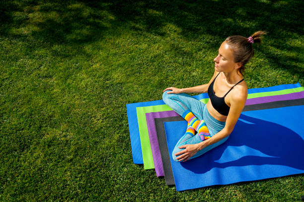 istock Woman practicing yoga in park green grass 1341066450