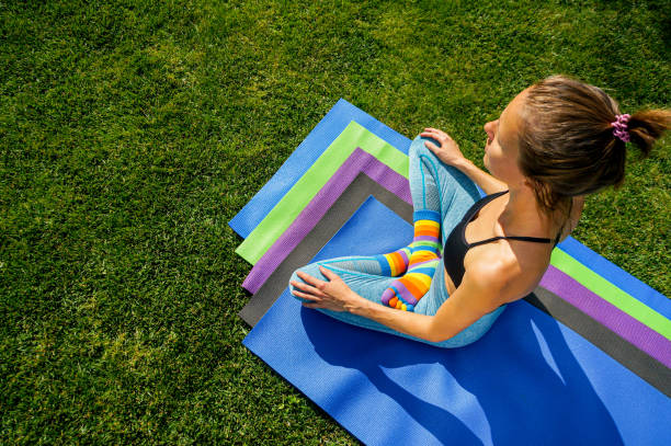 istock Woman practicing yoga in park green grass 1341066821