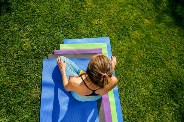 istock Woman practicing yoga in park green grass 1341066843