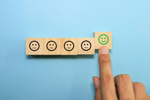 istock hand touching happy face emoticon on wooden cube.satisfaction and customer experience concept 1341067957