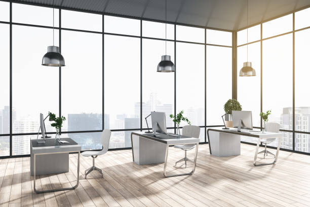 istock Modern coworking office interior with window and bright city view, desks, computer, monitors, chairs and wooden flooring with shadows. 3D Rendering. 1341068914