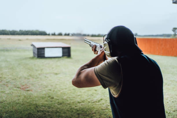 Man shooting shotguns at clay pigeon outdoors Shot in England. trap shooting stock pictures, royalty-free photos & images