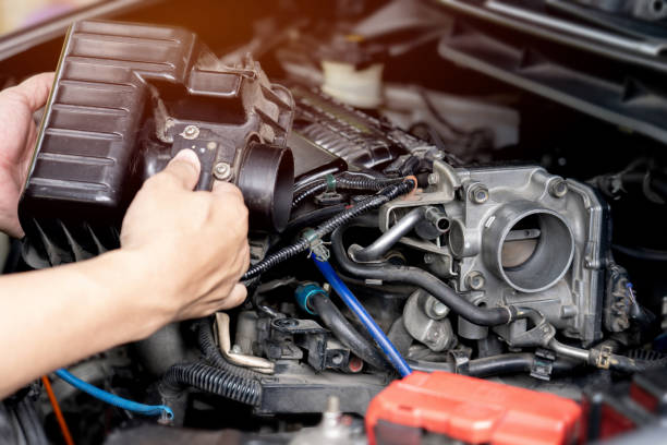 cerrar el acelerador viejo cuerpo del automóvil en la sala de máquinas con y un hombre sostener cubierta de llenado de aire en el servicio del automóvil limpieza y mantenimiento de la válvula del acelerador del motor: foto del concepto de servicio del  - throttle fotografías e imágenes de stock