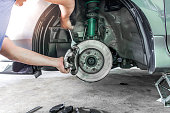 istock Hand a technician man repairing action and service disk brake for car,change Brake pads and system check in basic maintenance 1341071527