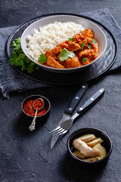 istock butter chicken with long grain rice and coriander, chicken curry in a bowl on a concrete table, english cuisine, vertical view from above 1341071581