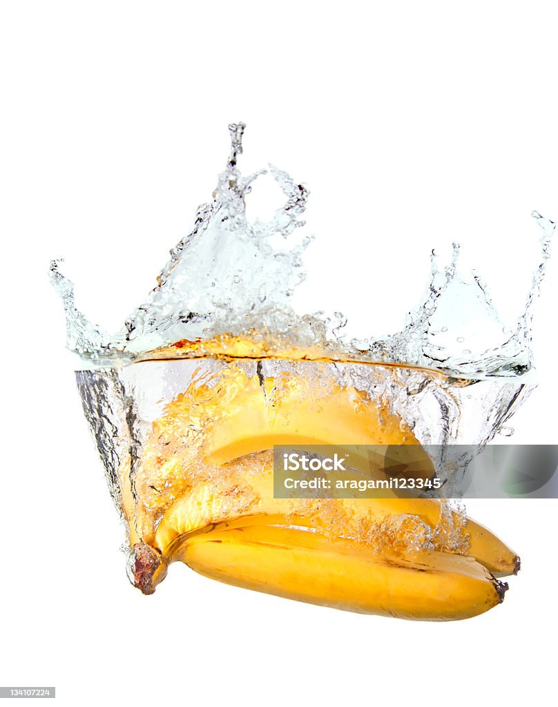 Pęk bananów w water splash na białym tle - Zbiór zdjęć royalty-free (Banan)