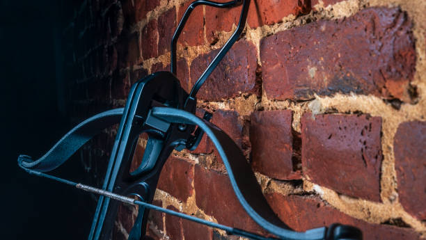 istock A modern compound crossbow handgun on the red brick wall background. Old weapon concept. 1341077615