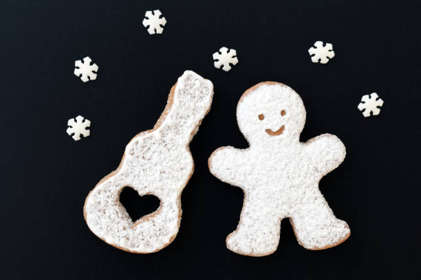 istock Music creative concept with sugared cookies - man and his guitar, decorated with small sugar snowflakes 1341078713
