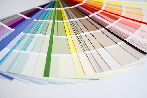 Photograph of a fanned colour swatch booklet on a wooden tabletop