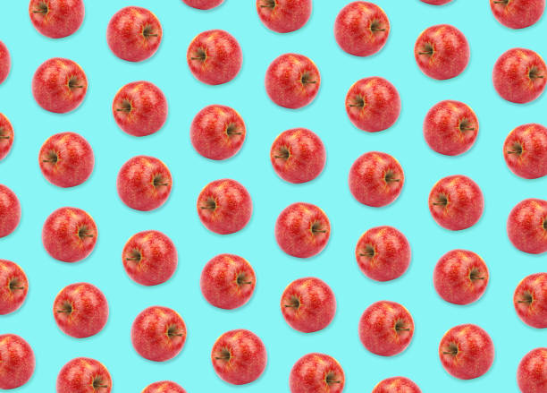 istock Pattern of red apples on light blue background 1341079881
