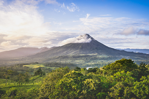 Tropical landscape with a volcano rolled by a cloud and the jungle at its feet. Costa Rica