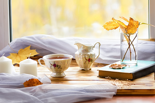 Tea set on the window. Outside the window is sunny autumn. Autumn still life
