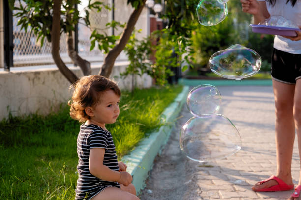 istock Happy carefree toddler boy blowing soap bubbles 1341084494