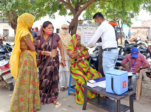 Beawar, Rajasthan, India, September 17, 2021: Health worker inoculate COVID-19 vaccine dose to a rajasthani woman under the shade of a tree on road during mega vaccination drive on Prime Minister Narendra Modi's 71st birthday in Beawar. India created a world record of highest number of over 2.50 crore COVID vaccine doses in a single day on September 17.