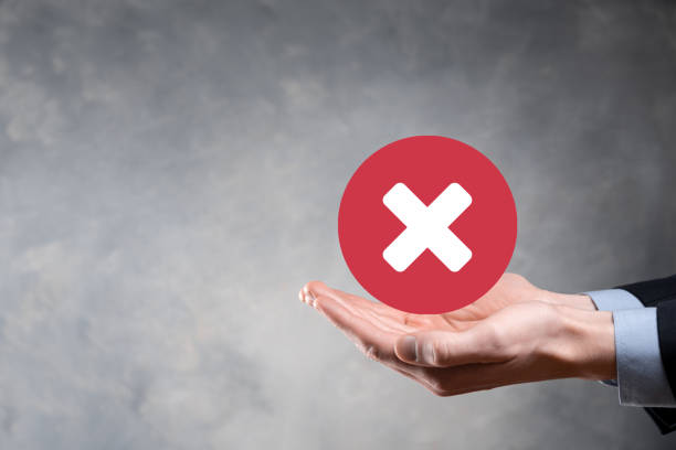 istock Hand holds icon,cancellation symbol,cancel icon.Cross mark flat red icon.round X mark.cancel button.Wrong.cross mark rejection.Declined.On dark background.Banner.Copy space.Place for text. 1341085337