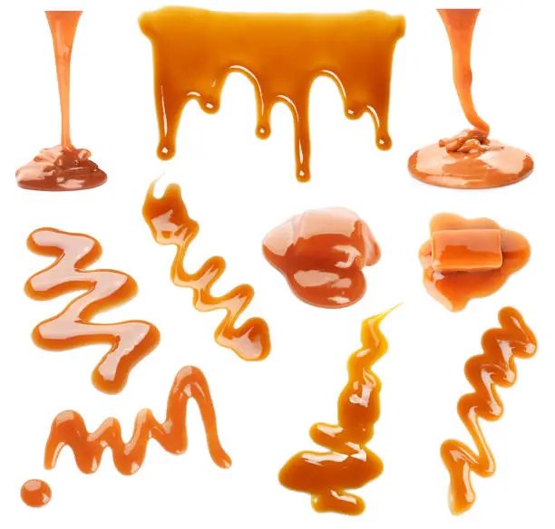 Photo of Set with caramel candies and tasty sauce on white background