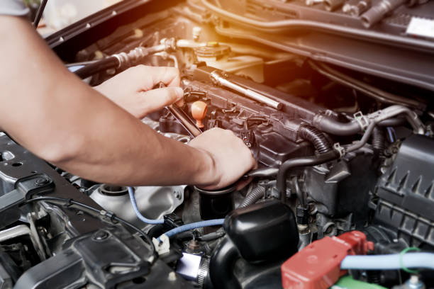istock Car spark plug in a hand of Technician and engine room blur background service concept 1341090235